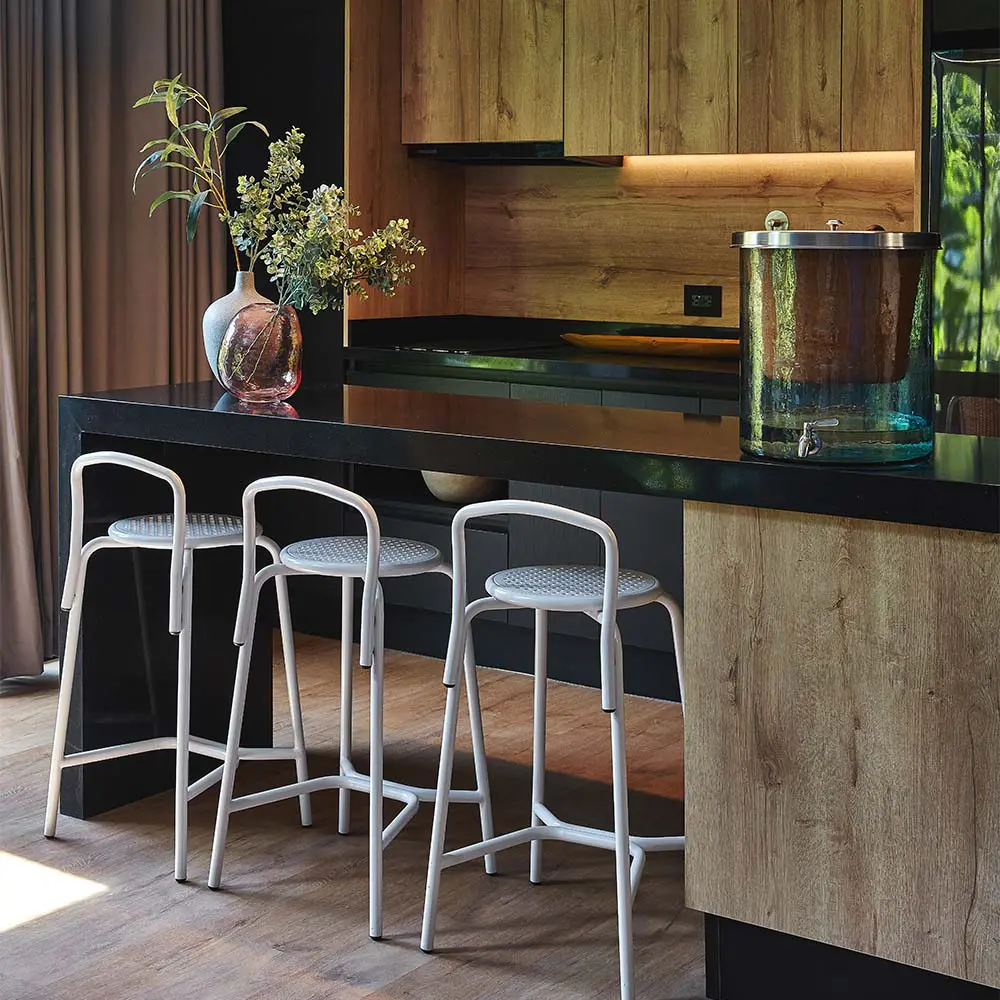 Un edificio en la zona rosa de medellín cargado de plantas tropicales y árboles