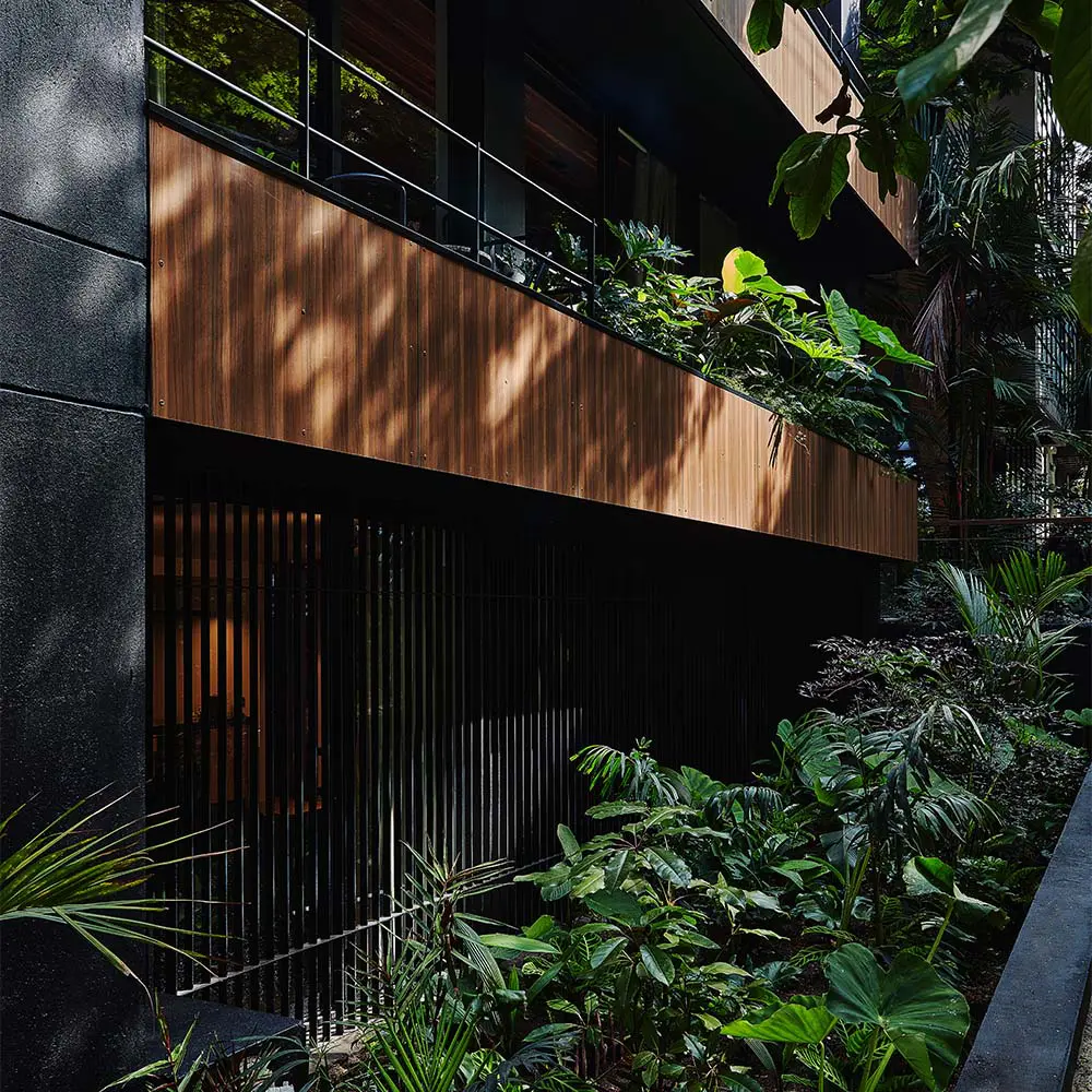 Un edificio en la zona rosa de medellín cargado de plantas tropicales y árboles