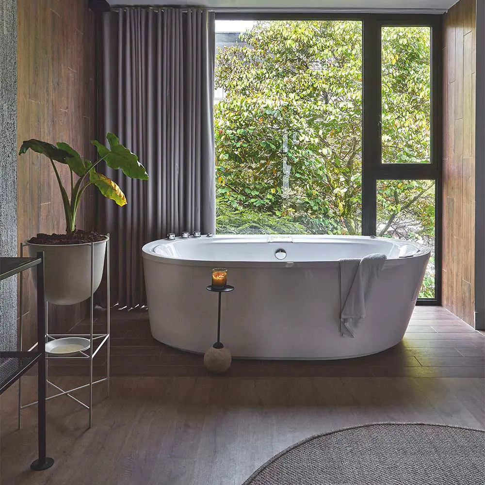 Un edificio en la zona rosa de medellín cargado de plantas tropicales y árboles