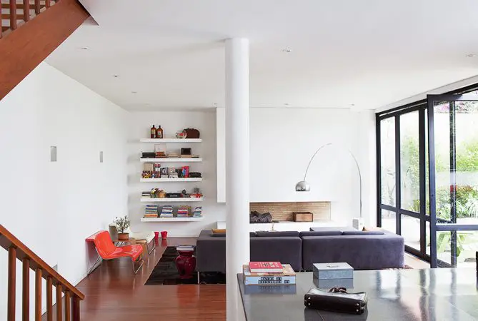 La sorprendente renovación de una casa de los años cincuenta en bogotá La columna central entre funciones de piso y la sala y el comedor es mesa de granito negro, un gesto típico de la donde los propietarios arquitectura de la década colocaron unos libros de 1950.
