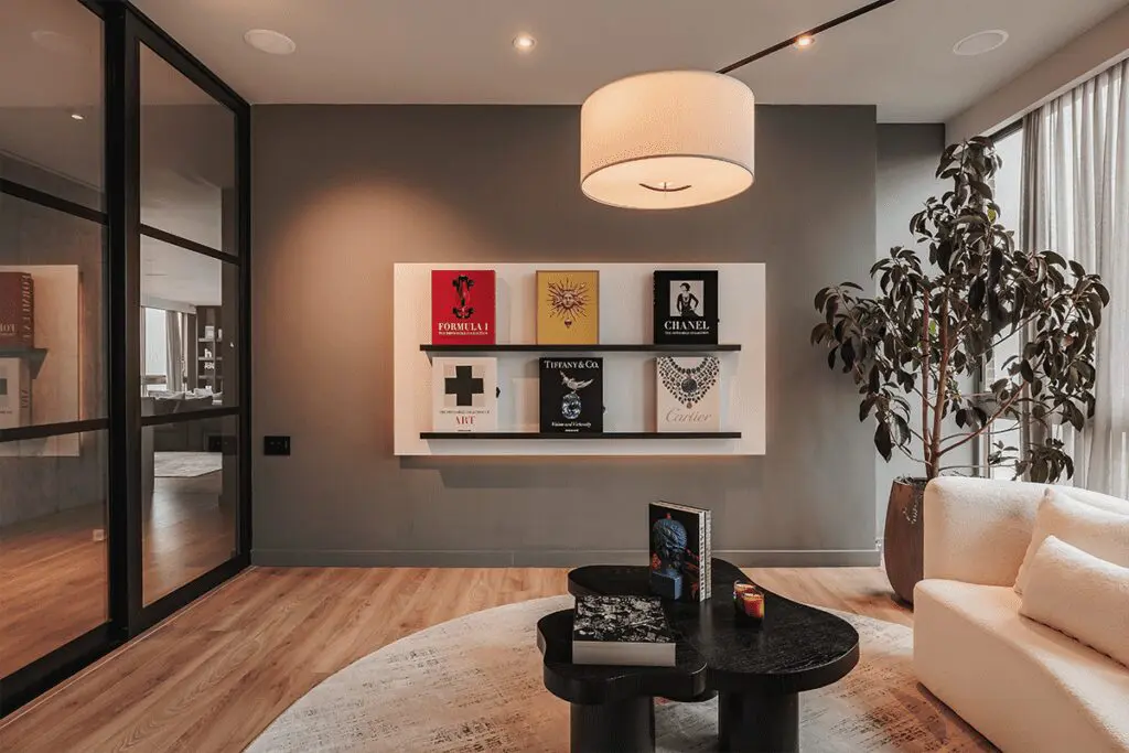 La sensación de resguardo de esta sala se logró a partir de la iluminación y un gran sofá La sensación de resguardo de esta sala se logró a partir de la iluminación y un gran sofá