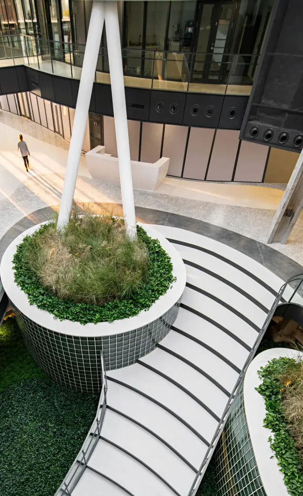 La transformación de una antigua fábrica de china en una oficina rodeada de un jardín