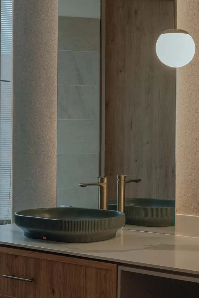 El espejo de este baño potencia la verticalidad y exalta la riqueza de los materiales