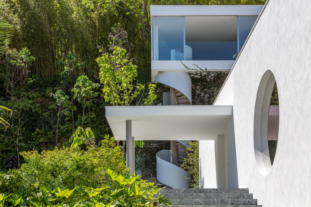 Una impactante escalera en caracol sube a esta casa diseñada por oscar niemeyer
