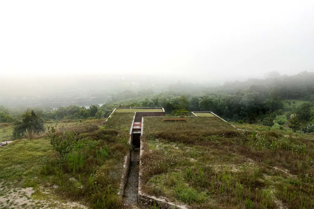 Una casa fundida en el paisaje de portugal: tiene cubiertas ajardinadas y muros de piedra