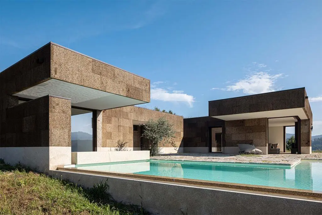 Una casa fundida en el paisaje de portugal: tiene cubiertas ajardinadas y muros de piedra
