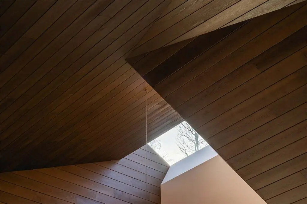 Techos voladizos, ventanales hacia el lago, salón de billar y chimeneas en este sereno chalet