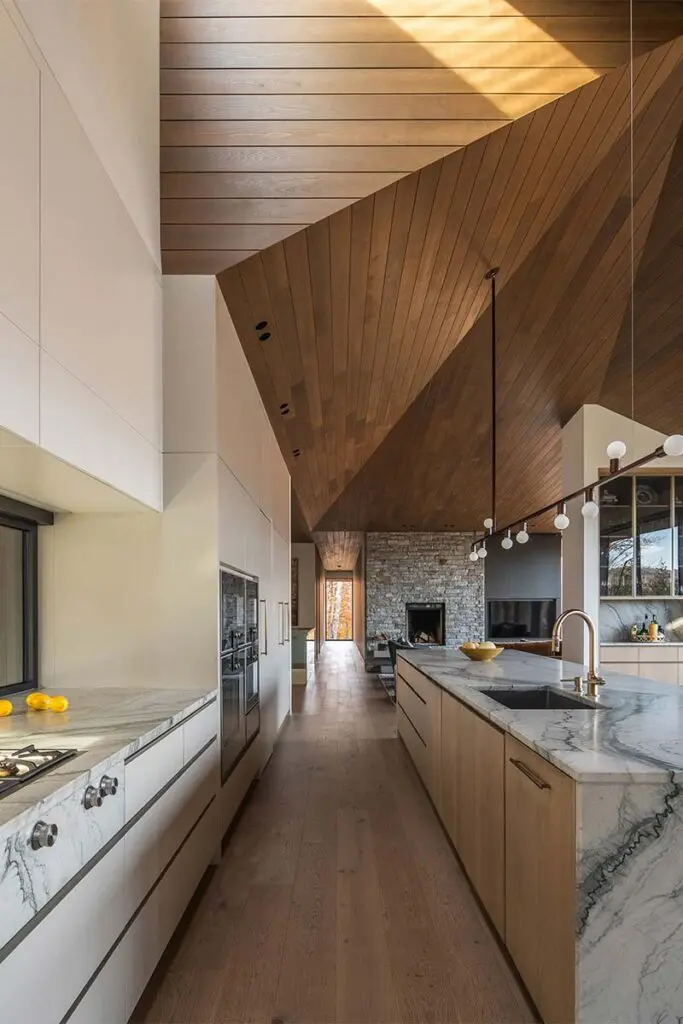 Techos voladizos, ventanales hacia el lago, salón de billar y chimeneas en este sereno chalet