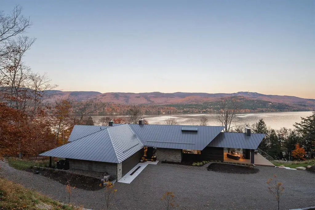 Techos voladizos, ventanales hacia el lago, salón de billar y chimeneas en este sereno chalet