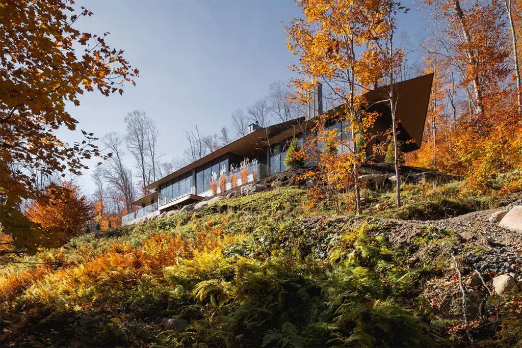 Techos voladizos, ventanales hacia el lago, salón de billar y chimeneas en este sereno chalet
