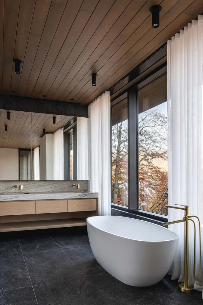 Techos voladizos, ventanales hacia el lago, salón de billar y chimeneas en este sereno chalet