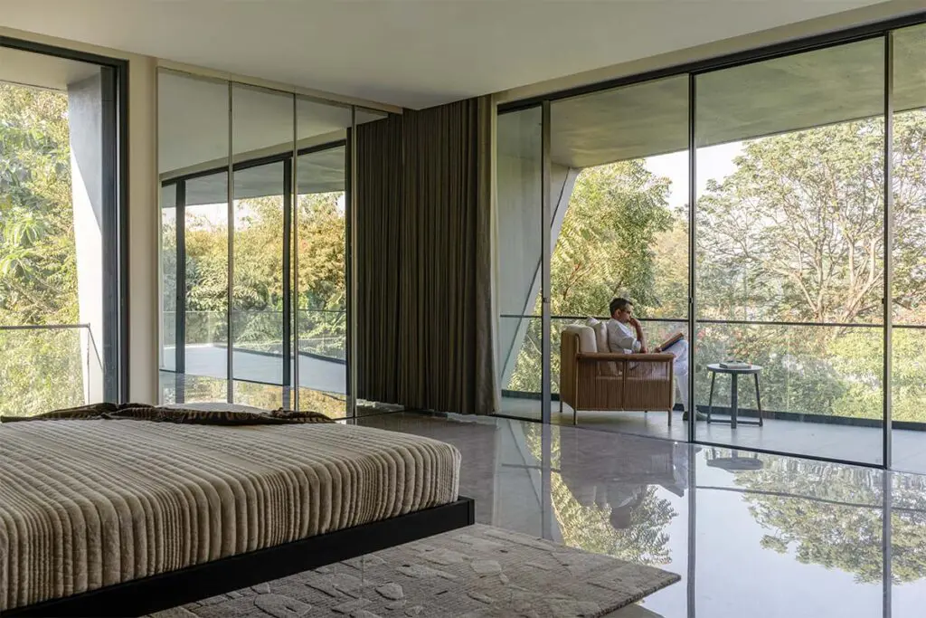 El arte de habitar el paisaje: una casa en india cercada por frondosos árboles