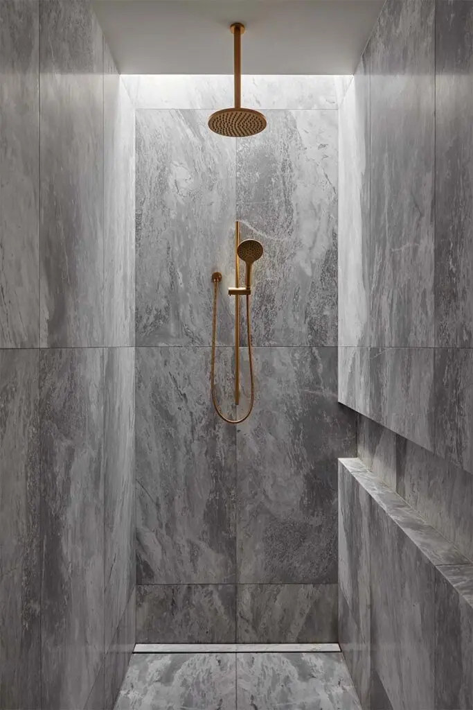 El mármol negro define el lenguaje arquitectónico de este baño El mármol negro define el lenguaje arquitectónico de este baño