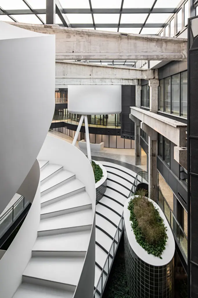 La transformación de una antigua fábrica de china en una oficina rodeada de un jardín