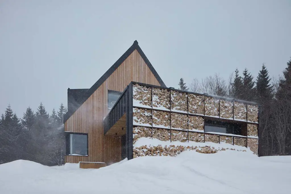 Una casa en la nieve con un diseño en armonía con la arquitectura local