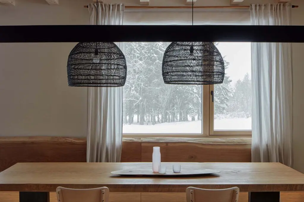 Una casa en la nieve con un diseño en armonía con la arquitectura local