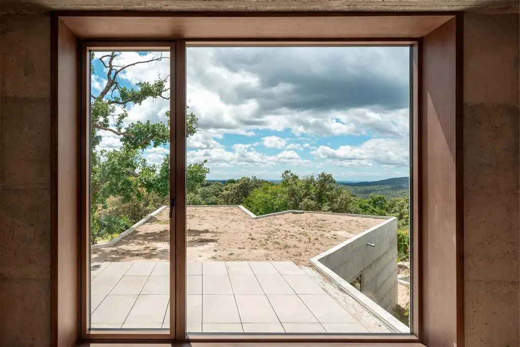 Una casa entre rocas y robles en españa, con una arquitectura cruda y atemporal