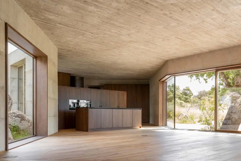 Una casa entre rocas y robles en españa, con una arquitectura cruda y atemporal