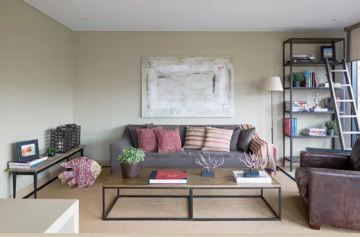 La banqueta en la que está el portarretratos de cuero pertenece a la colección Antique, de Becara, y fue importada de Indonesia. Es una pieza única de la división de antigüedades de la firma. Los cojines color berenjena, tapizados con dhurrie, son fuente principal de tonos cálidos, mientras que el tapete de fique aporta una textura rústica al área.