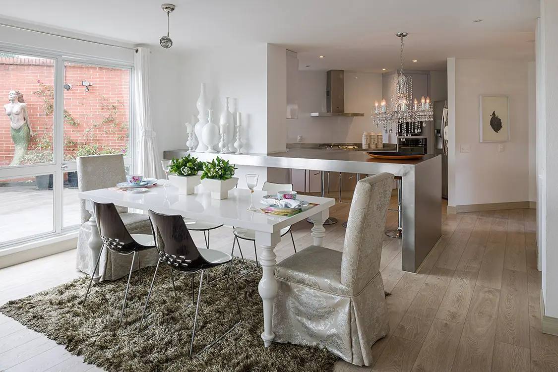 La casa de un amante de la estética Tres floreros y cuatro candelabros blancos, de z gallerie, decoran el final de la barra de acero que da paso a la cocina.