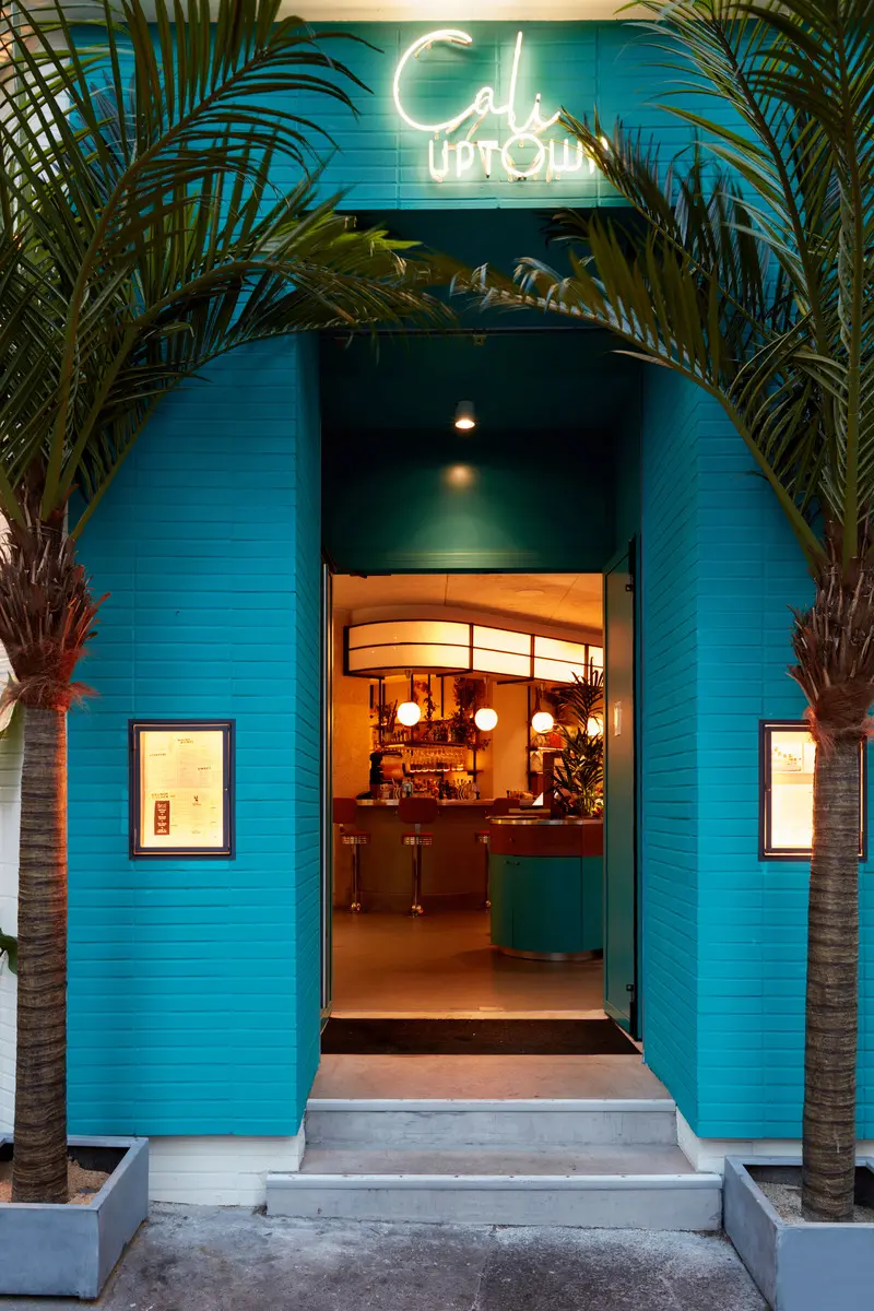 Press kit | 5857-01 - press release | cali uptown - studio unltd - commercial interior design -  the entry is flanked by columns of cheerful, peacock blue. - photo credit: le boulicaut photographe