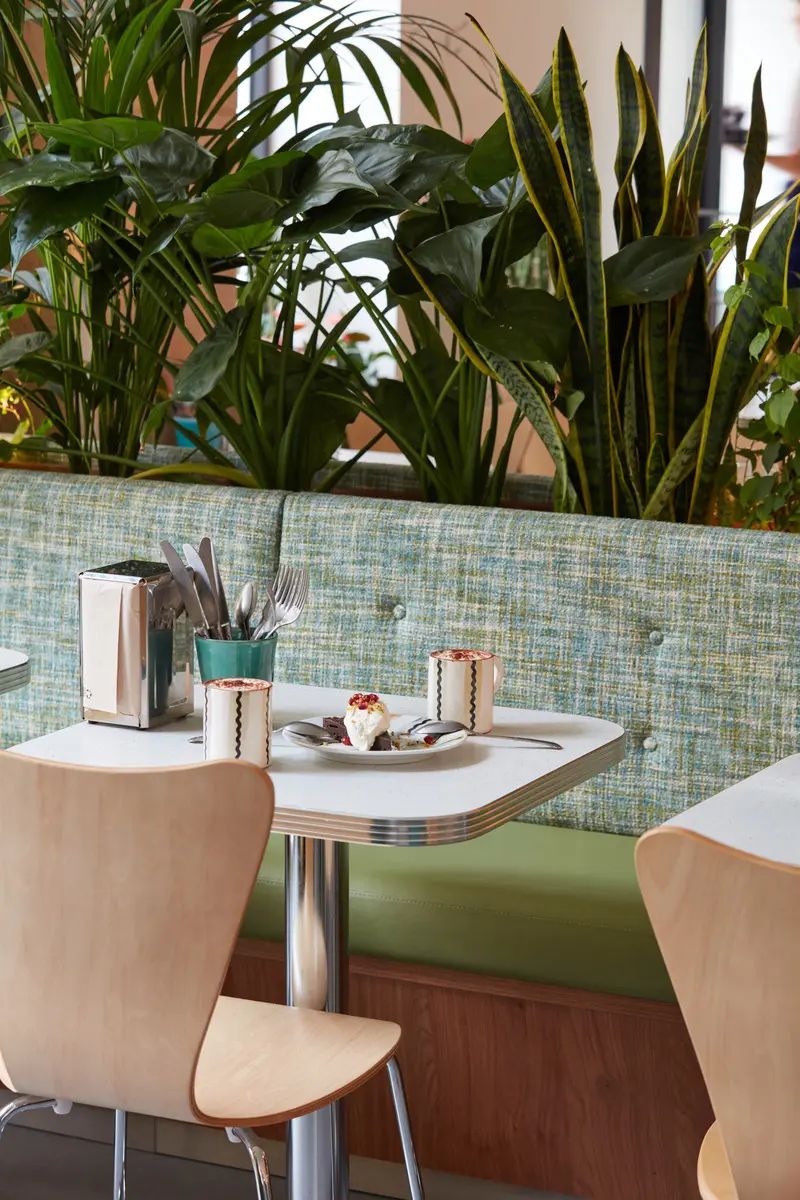 Press kit | 5857-01 - press release | cali uptown - studio unltd - commercial interior design -  tables sourced from american restaurant supply stores feature laminate tops and chrome banding and booths are upholstered in ivy green vinyl inspired by vintage car colors. - photo credit: le boulicaut photographe