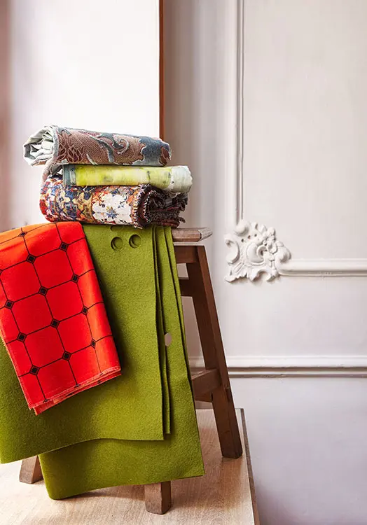 Tela de algodón y cupro, ref. Toma, diseño de fadini borghi; tela de lino con bordados y motivo de cactus, ref. Cuilko, diseño de pierre frey; tela en tonos naranjas y azules, ref. Azulejos mandarine, diseño de jean-paul gaultier; terciopelo naranja ciento por ciento de algodón, ref. Zen, diseño de jean-paul gaultier, todo lo anterior en michel editores. Tiro decorativo de fieltro, de dw textiles.