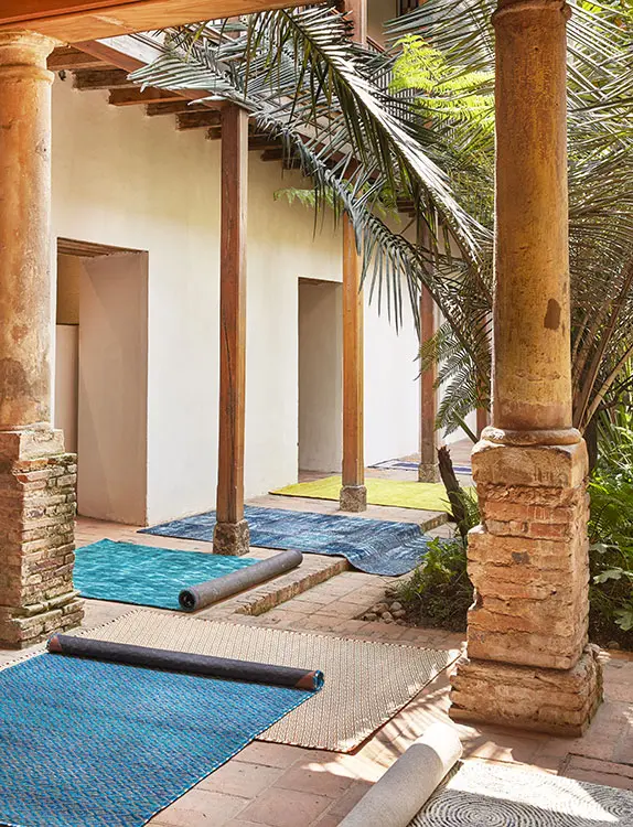 Tapete para exterior azul oscuro y crema, ref. Athens, de la marca fab habitat; tapete verde, ref. Karastan, ambos en alfa. Tapete en patchwork azul, en q design. Tapete azul turquesa, ref. Ferreira, de zientte. Tapete tejido de fibras naturales color crema e hilo de cobre; tapete azul tejido de fibras naturales y estaño, ambos de carpetta. Tapete, ref. Warla harbour blue, de tejidos lav.