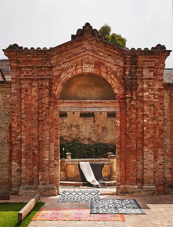 Tapete negro y tapete blanco de hilo, lana y crin, ref. Cordoncillo, hecho en telar horizontal, de la escuela de artes y oficios santo domingo. Dhurrie de lana, ref. D black, de tejidos lav. Tapete para exteriores negro y crema, ref. Venice, de la marca fab habitat; tapete para exteriores violeta y naranja, ref. Lhasa, de la marca fab habitat, ambos en alfa.