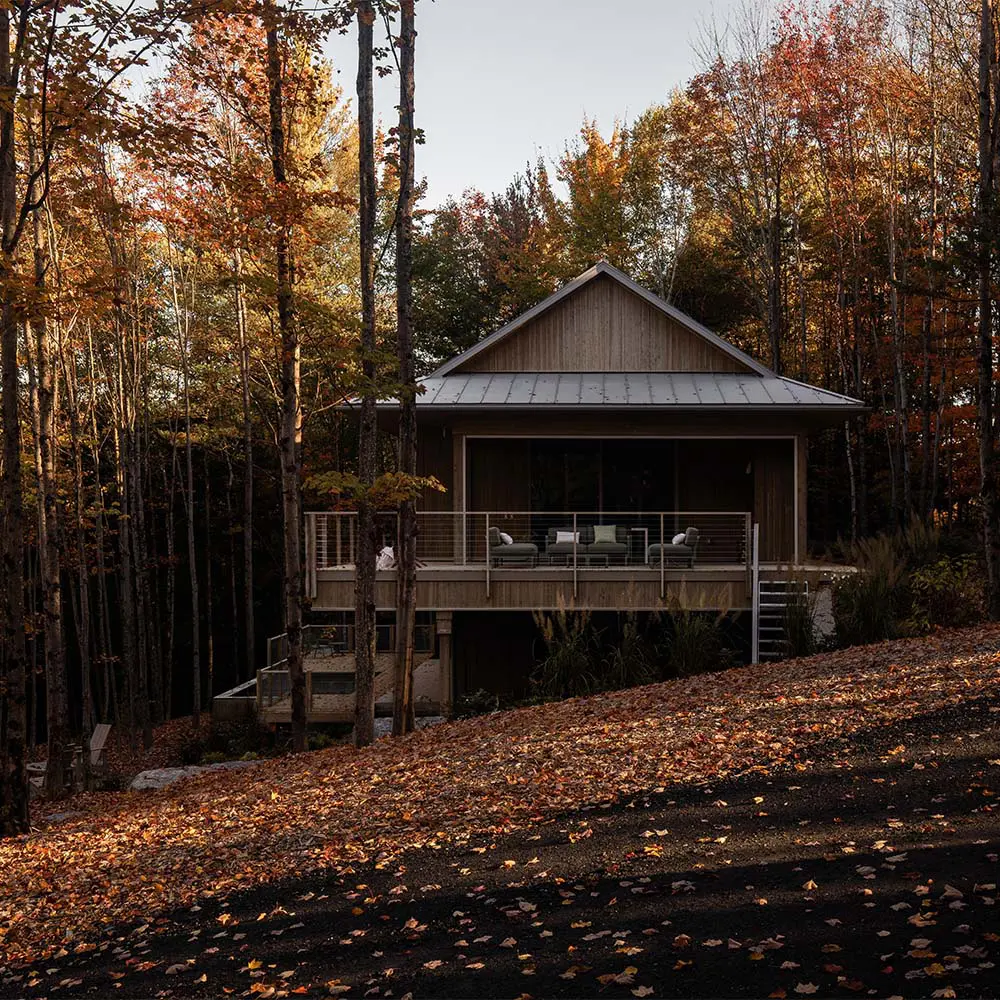 Una casa que se posa sobre el terreno para vivir entre árboles