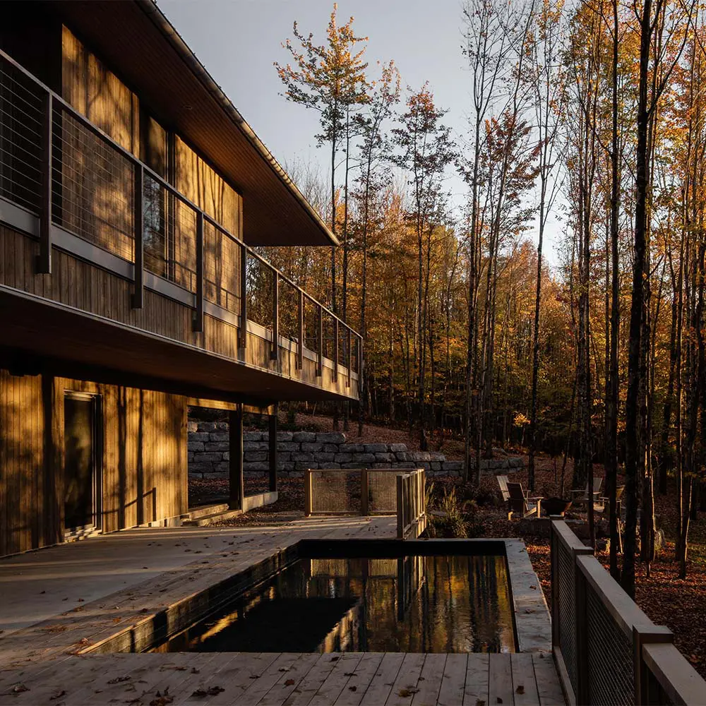 Una casa que se posa sobre el terreno para vivir entre árboles