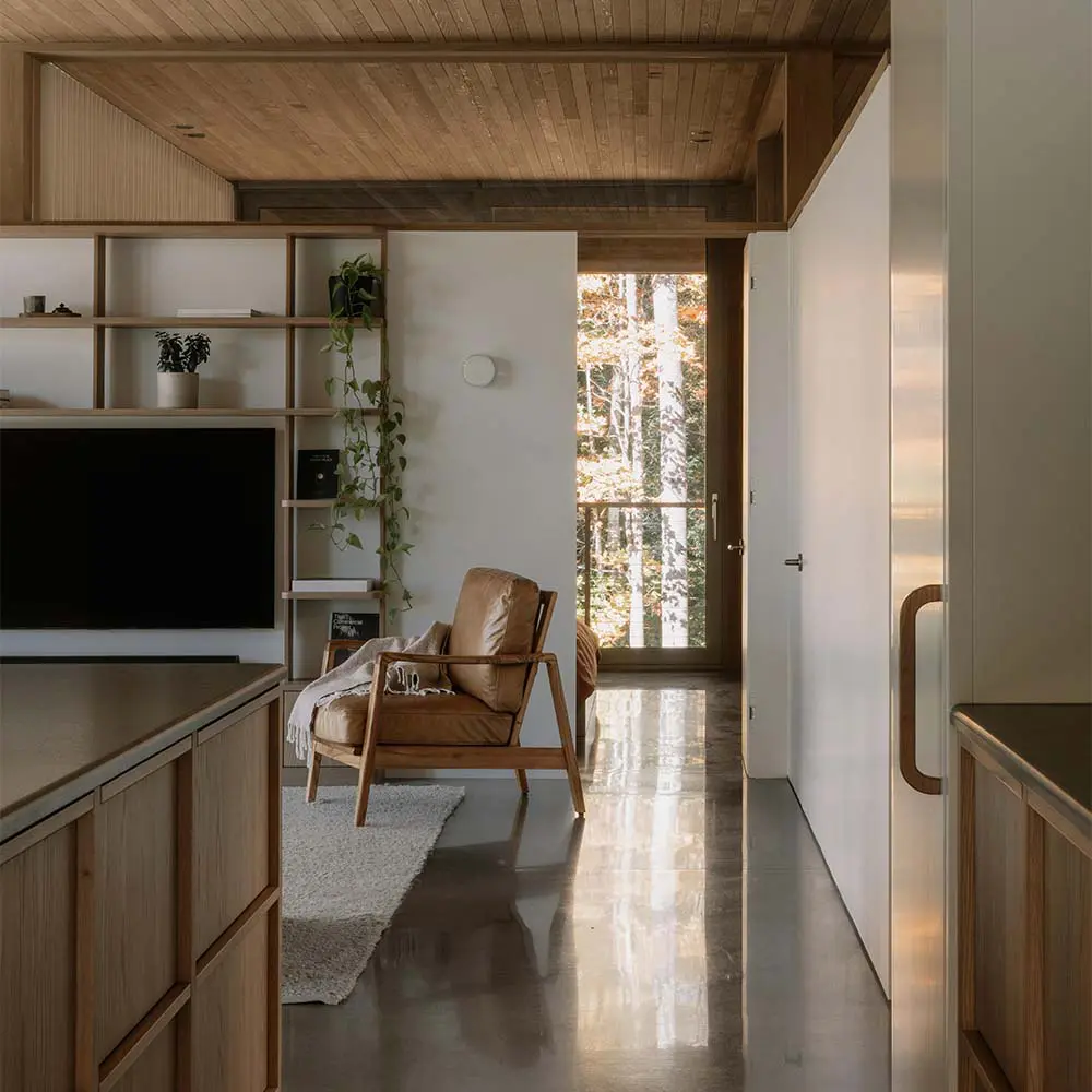 Una casa que se posa sobre el terreno para vivir entre árboles