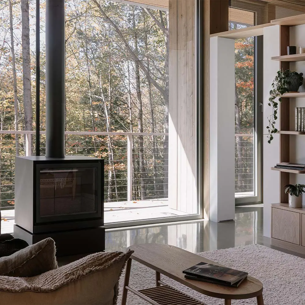 Una casa que se posa sobre el terreno para vivir entre árboles