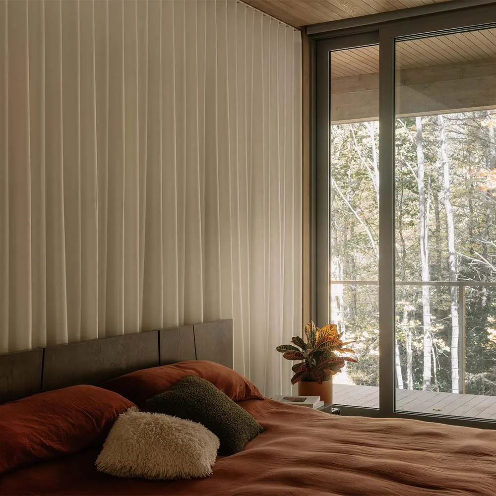 Una casa que se posa sobre el terreno para vivir entre árboles