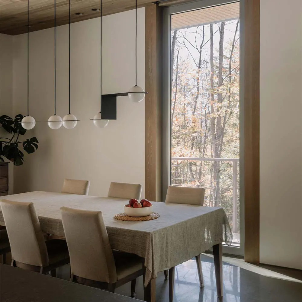 Una casa que se posa sobre el terreno para vivir entre árboles