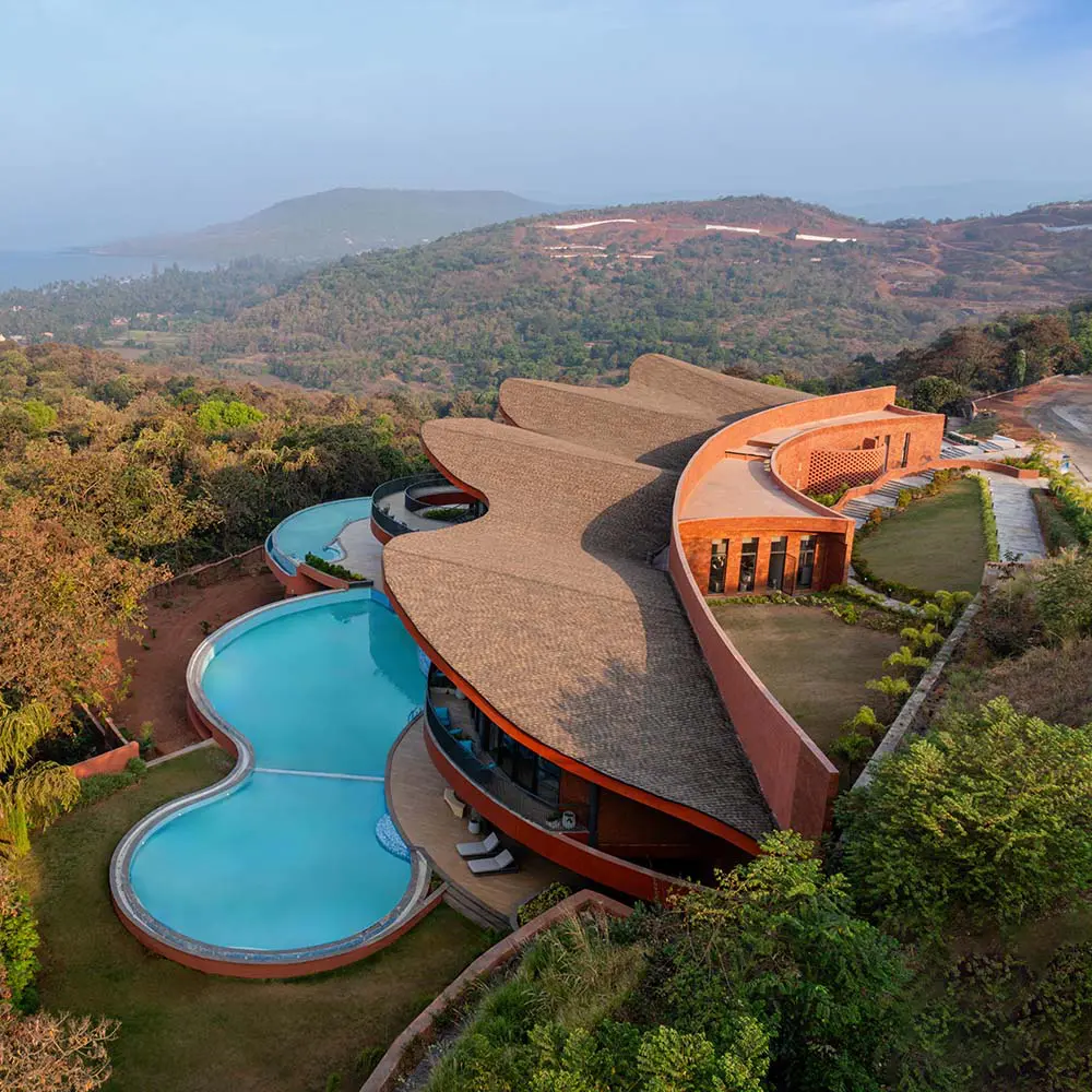 Un edificio en la india moldeado por curvas, terrazas y vistas al mar