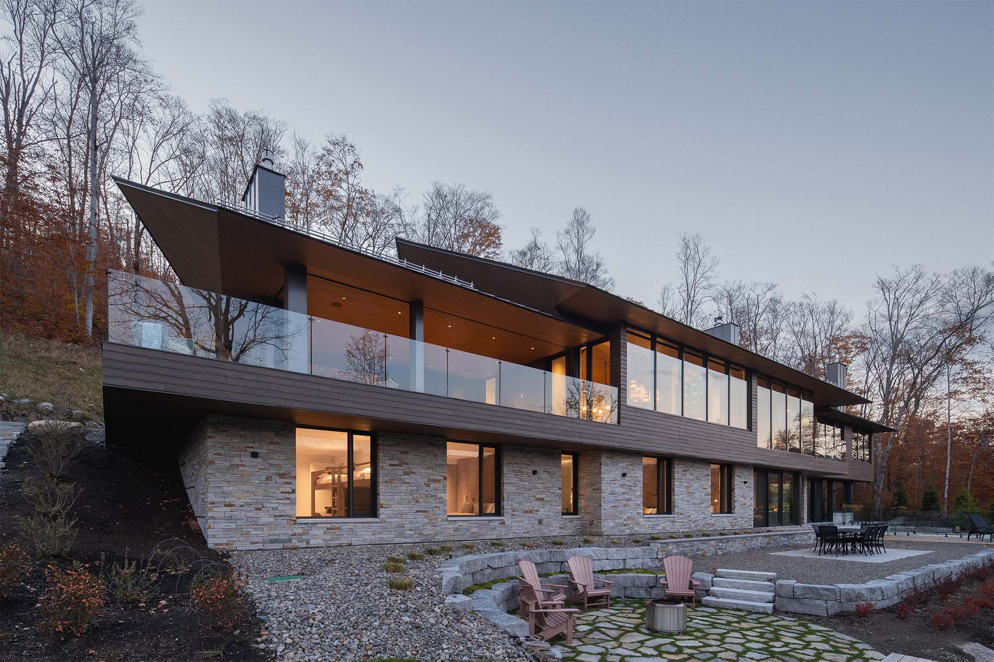 Techos voladizos, ventanales hacia el lago, salón de billar y chimeneas en este sereno chalet