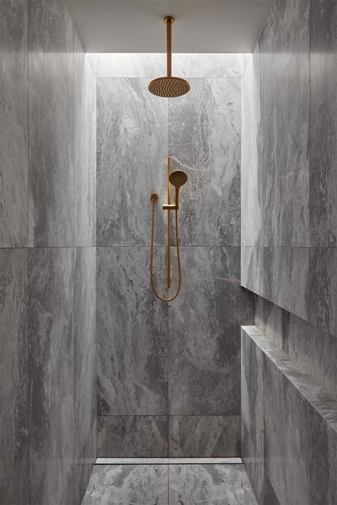 El mármol negro define el lenguaje arquitectónico de este baño